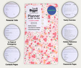 A floral monthly planner cover shown centered on a light beige background, surrounded by circular callouts labeled for personal info, emergency contacts, contacts pages, yearly overview, holidays reference pages, passwords pages, and a monthly calendar. The planner reads &
