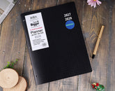 A black grid planner with a white &