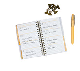 Open planner with daily schedule, pen, and decorative items on a white background